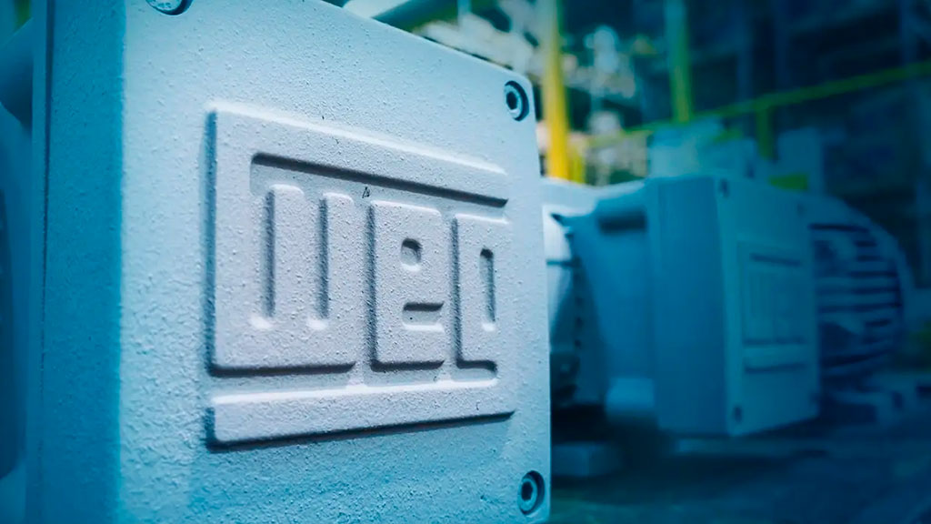 Equipamento industrial com logo da WEG em destaque na estrutura metálica em primeiro plano